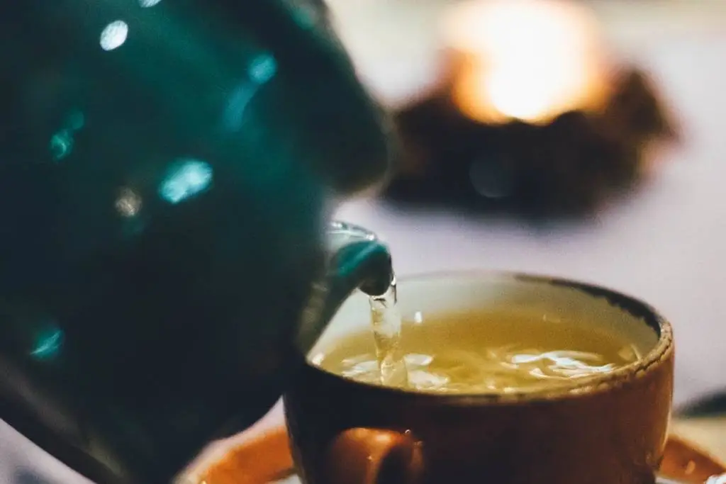 babhéj tea, tea öntése egy kancsóból a teás csészébe